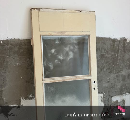 דלת עץ עם זגוגיות זכוכית טקסטורה במהלך שיפוץ